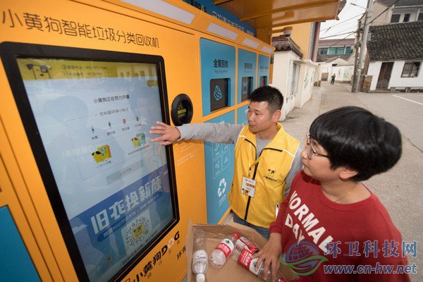 10月30日，在道場(chǎng)鄉(xiāng)錢山下村，工作人員（左）指導(dǎo)村民在智能回收機(jī)上進(jìn)行垃圾分類回收。